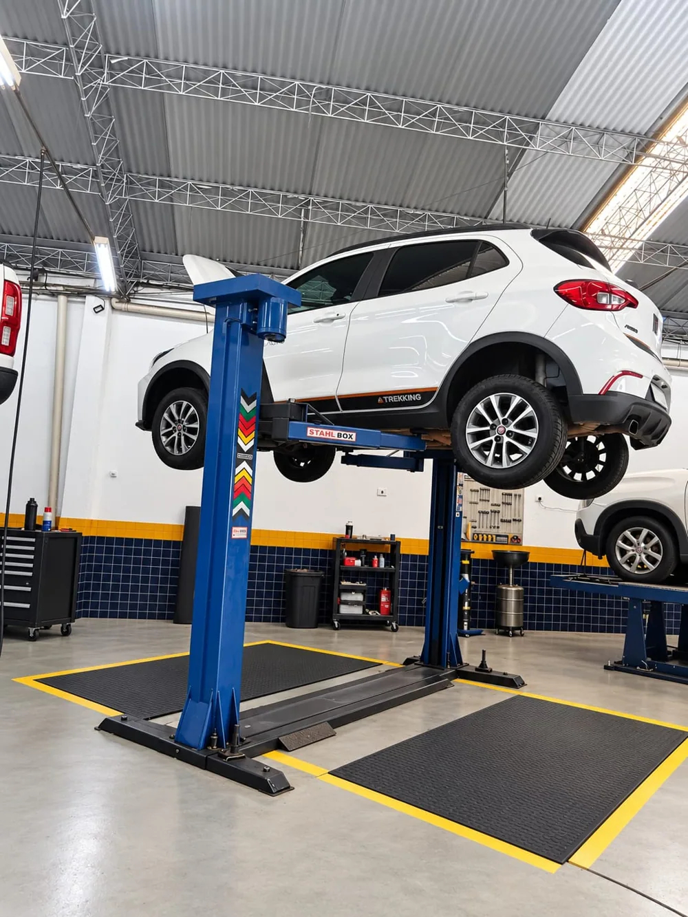 Carro branco elevado em uma das áreas de serviço da Master Auto Service